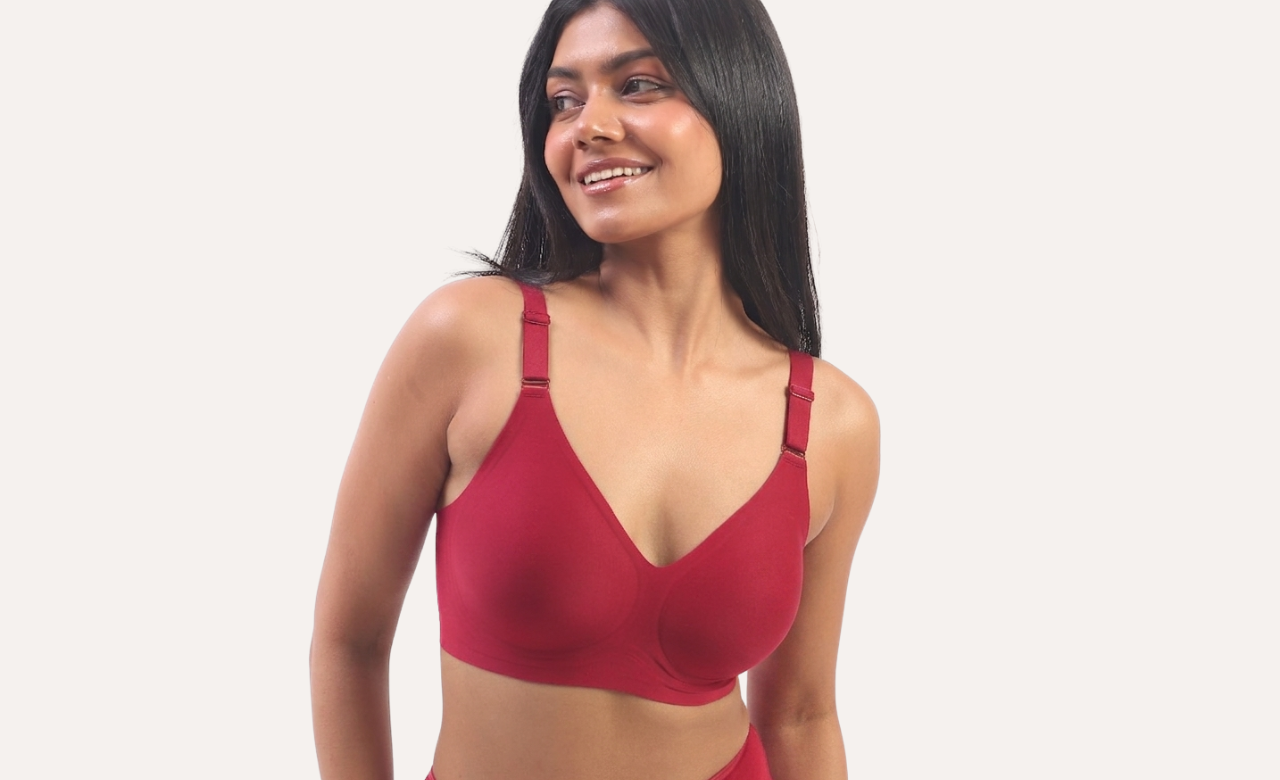 Woman wearing a red bra against a plain background