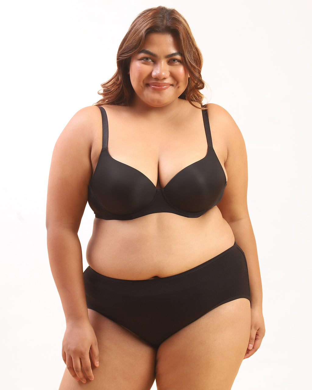 Woman wearing a black bra and panties set on a white background