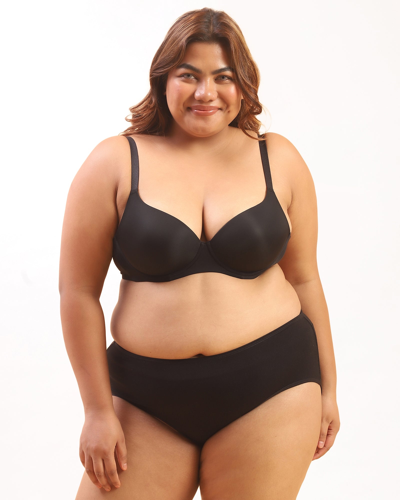 Woman wearing a black bra and panties set on a white background